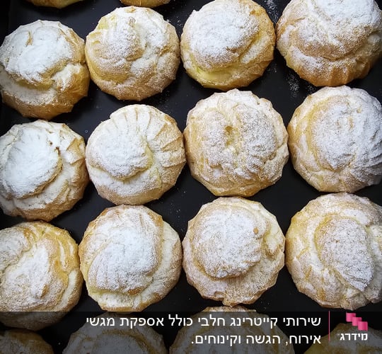 מאפים עגולים עם אבקת סוכר על מגש שחור